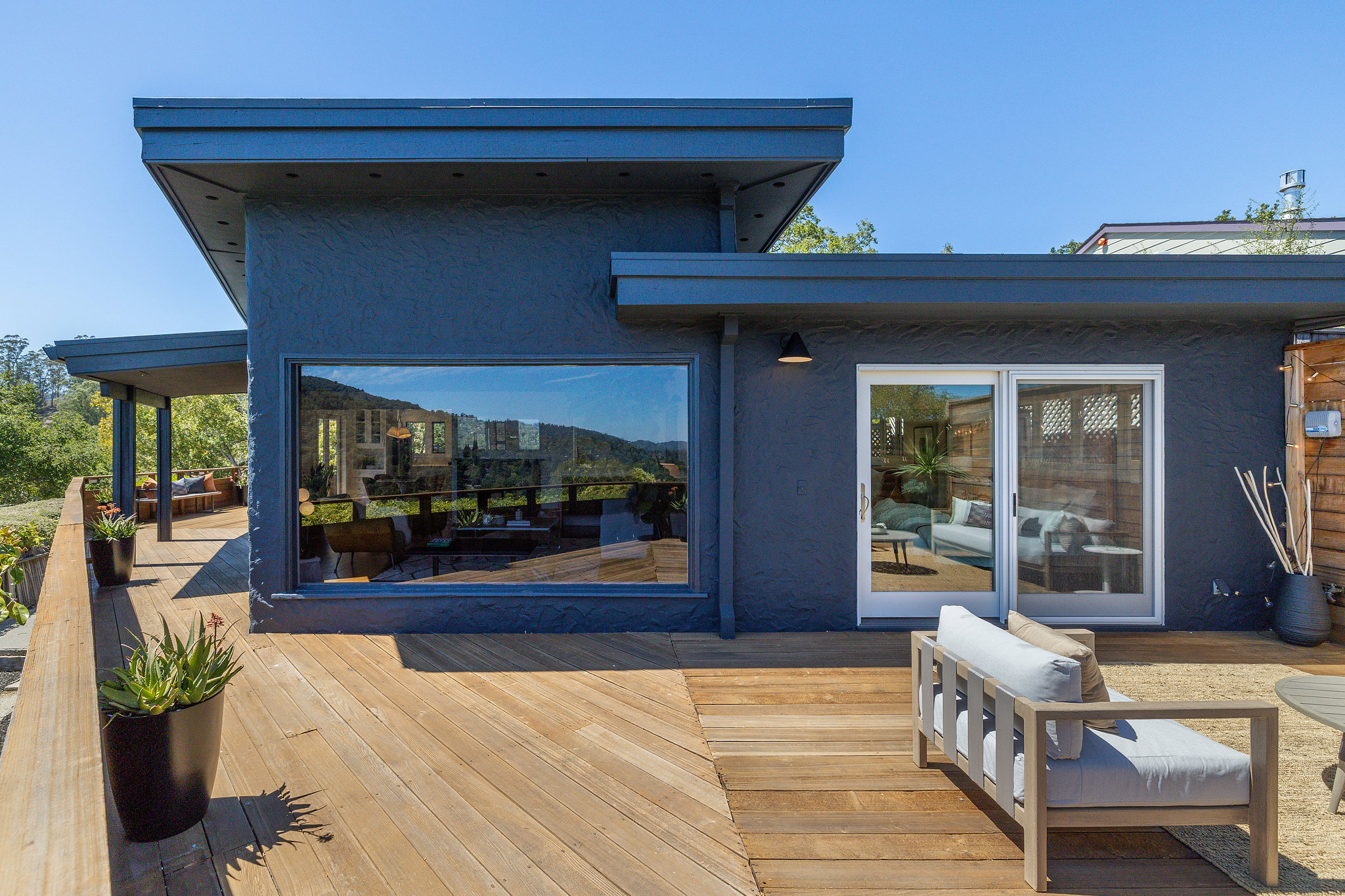 View of a home in Marin Country, listed by agent Chris Glave, showing a home with blue facade and a wrap around deck