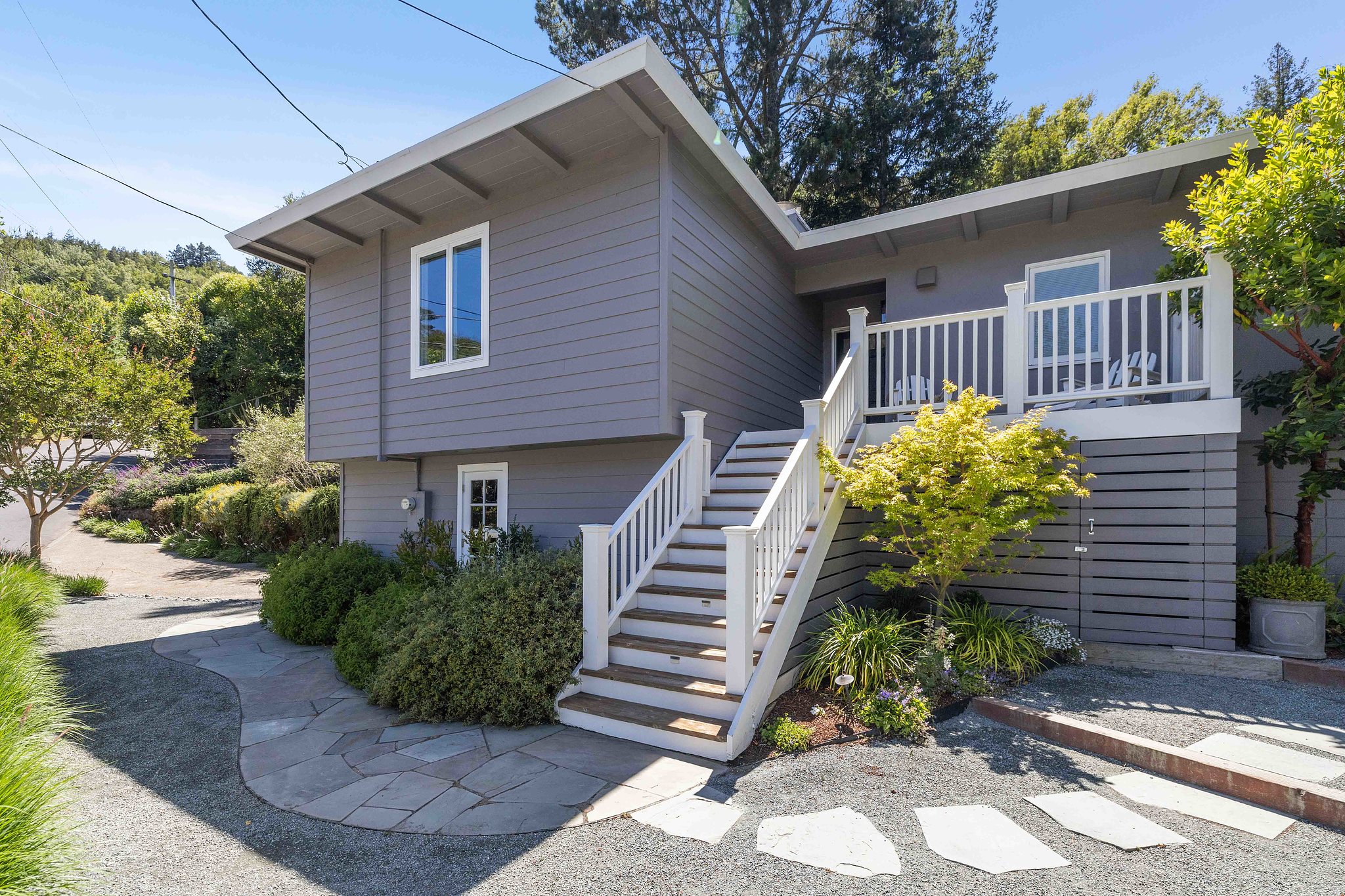 Exterior view of 473 Montecito Drive in Corte Madera, showing a grey home with a large yard