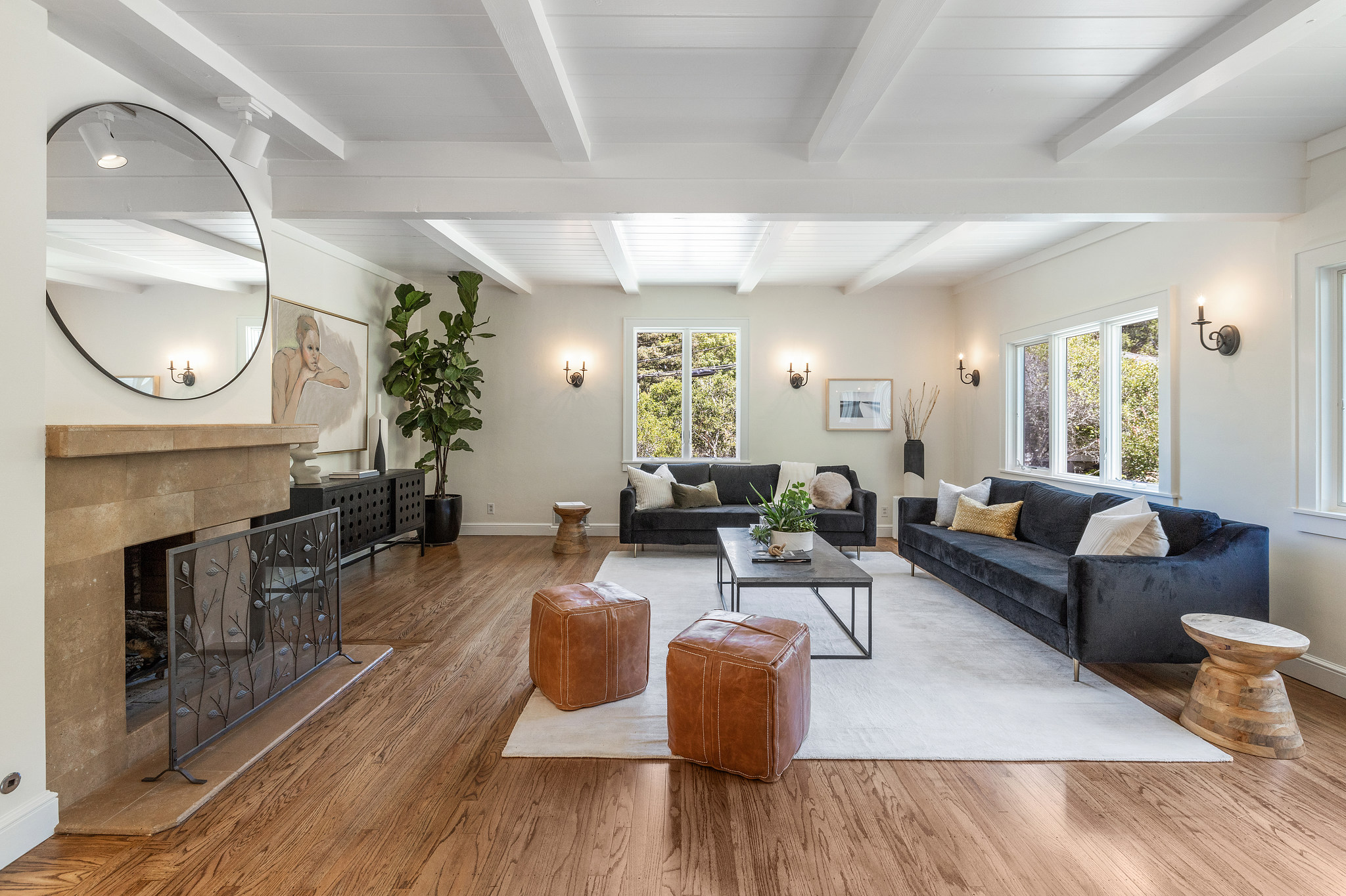 Living room with large windows, fireplace, and refinished floors