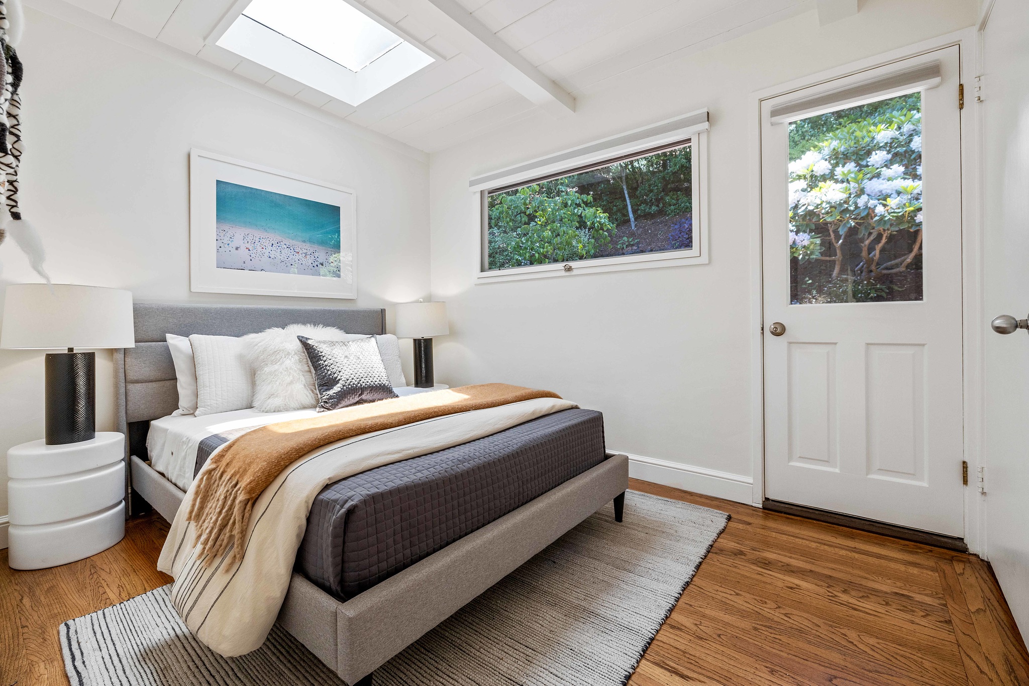 Second bedroom with skylight and refinished wood floors