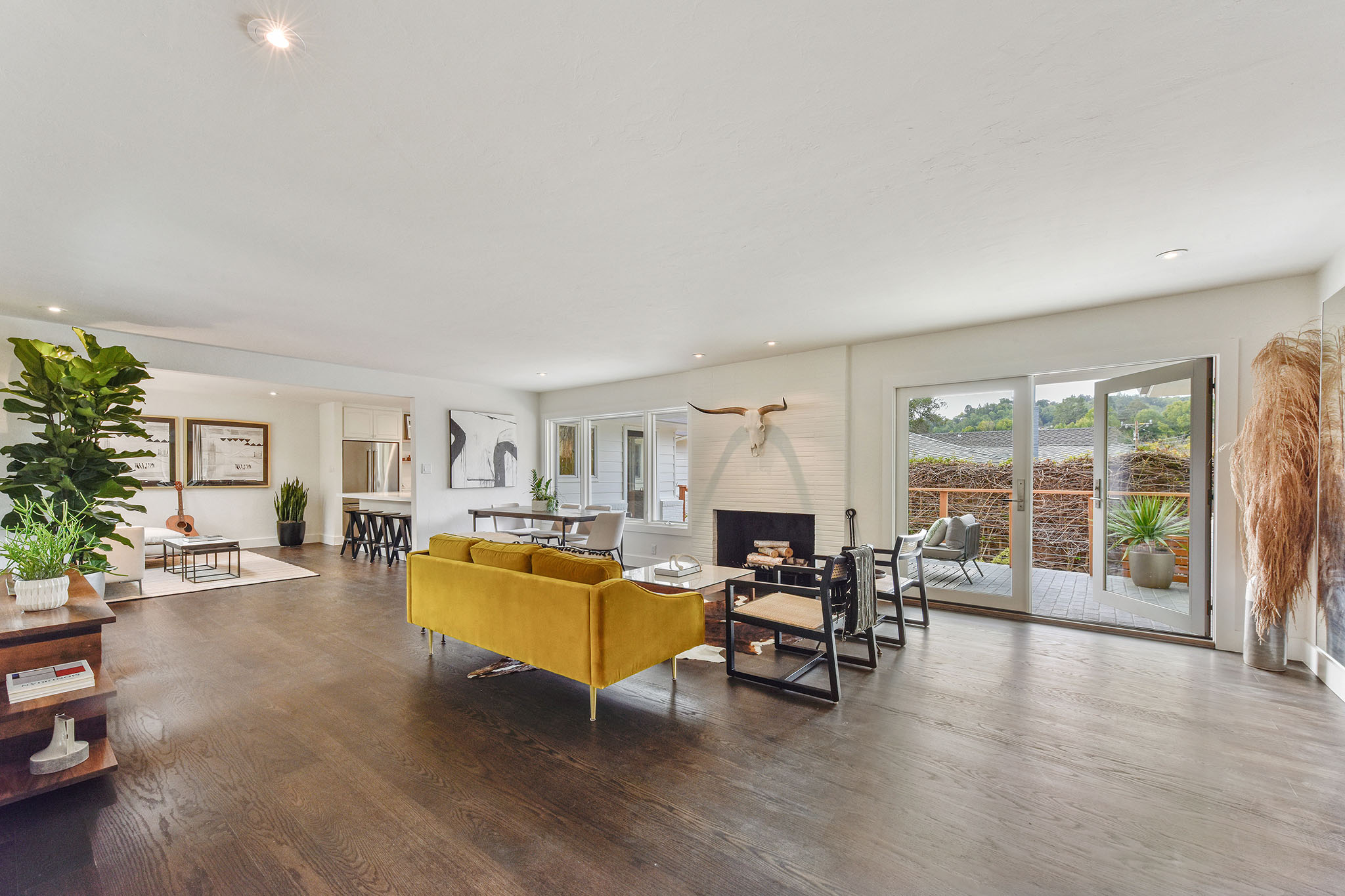 Open floor plan view of the primary living spaces featuring wood floors and a fireplace