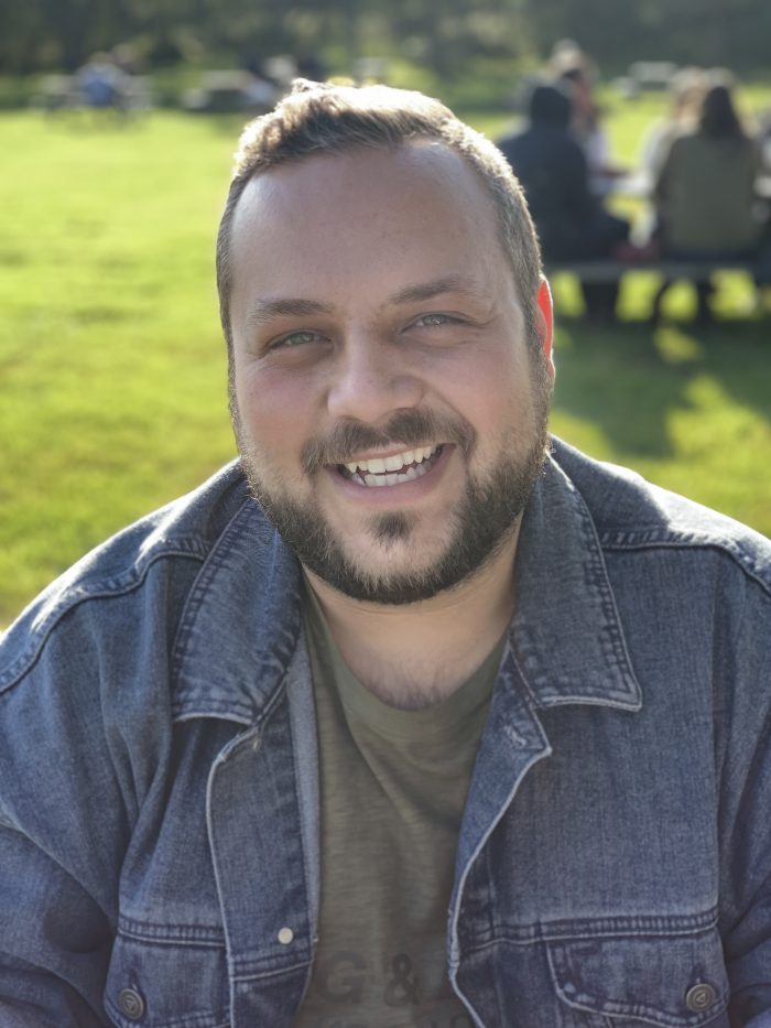 Man in denim jacket at the park.