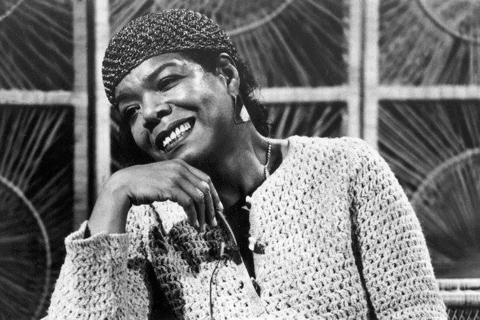 View of a Angelou, seen smiling with her hand near her face
